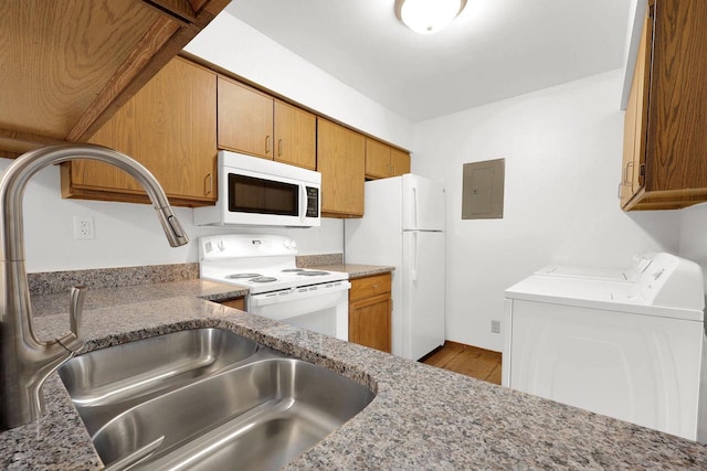 kitchen featuring white appliances, separate washer and dryer, stone counters, and hardwood / wood-style flooring