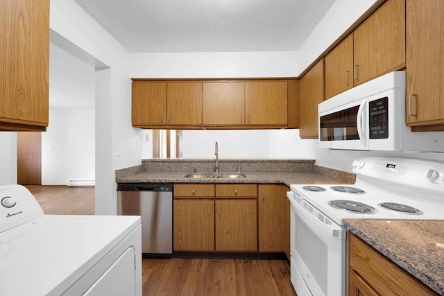 kitchen featuring sink, light stone countertops, dark hardwood / wood-style floors, washer / clothes dryer, and white appliances