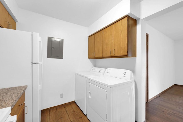 laundry room with electric panel, cabinets, washing machine and clothes dryer, and dark hardwood / wood-style floors