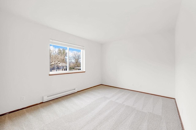 carpeted spare room featuring a baseboard heating unit