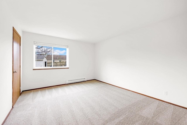 carpeted empty room featuring a baseboard heating unit