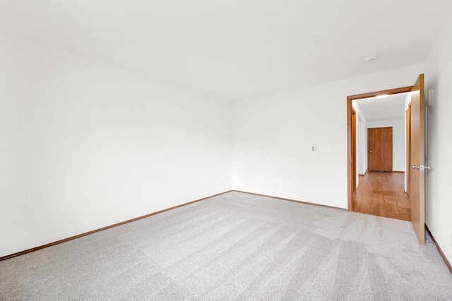 spare room featuring light carpet