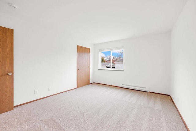 unfurnished room with baseboard heating and carpet floors