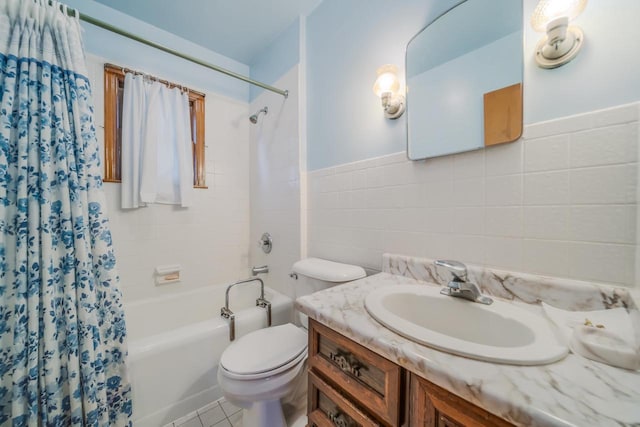 full bathroom featuring toilet, vanity, shower / bath combo, and tile walls