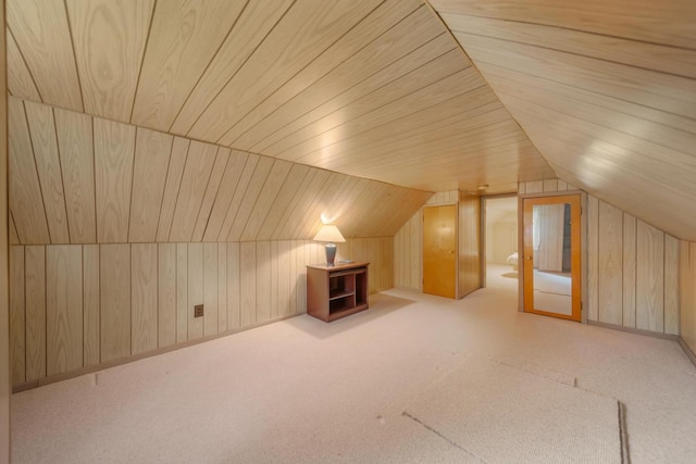 additional living space with wood walls, light colored carpet, vaulted ceiling, and wooden ceiling