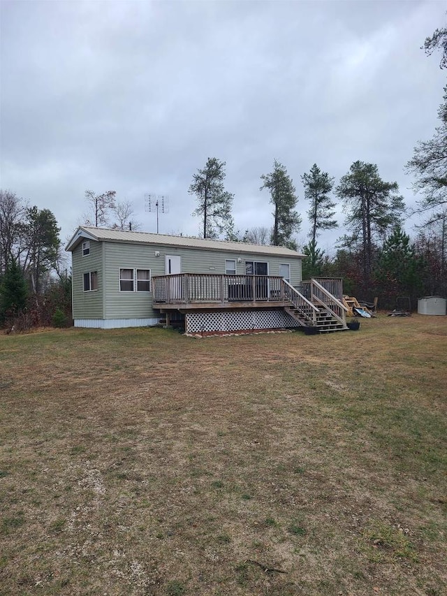 back of property featuring a wooden deck and a yard