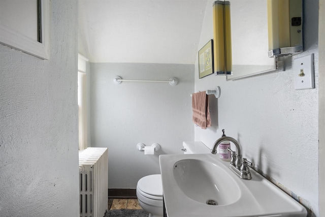 bathroom featuring sink, toilet, and radiator