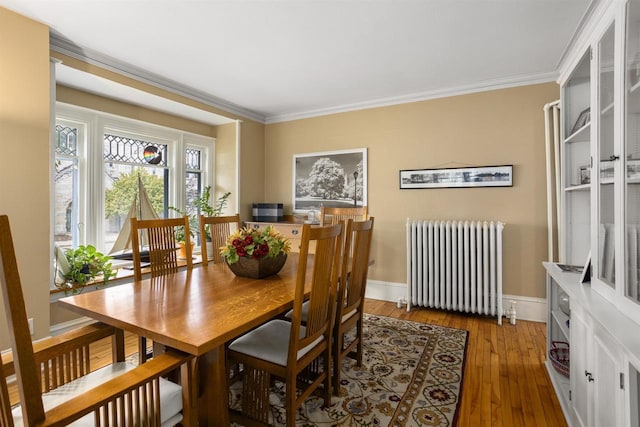 dining space featuring radiator heating unit, dark hardwood / wood-style floors, and crown molding