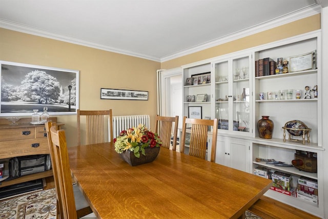 dining space featuring radiator heating unit and crown molding