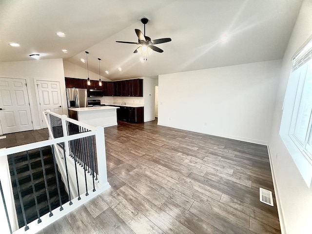 kitchen with stainless steel appliances, hanging light fixtures, lofted ceiling, a center island, and light wood-type flooring