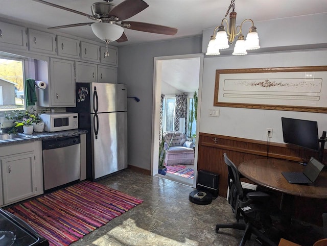 kitchen with ceiling fan with notable chandelier, appliances with stainless steel finishes, and decorative light fixtures