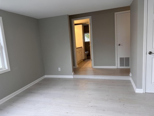 unfurnished room featuring a healthy amount of sunlight and light wood-type flooring