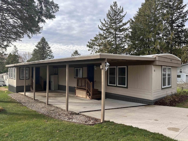 back of property featuring a carport and a lawn