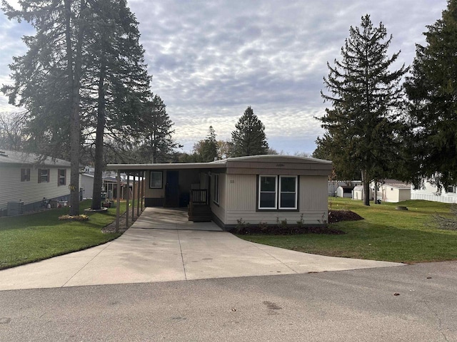 manufactured / mobile home with a front lawn and a carport