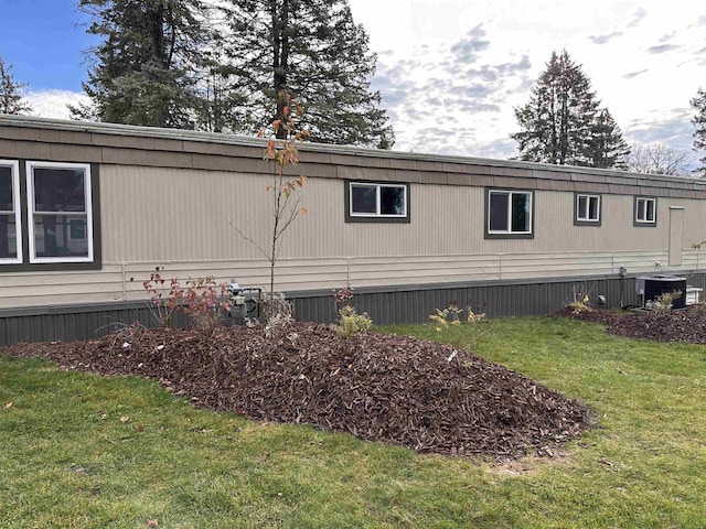 view of property exterior with central AC and a yard