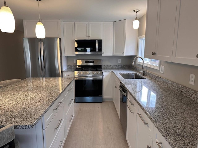 kitchen featuring white cabinets, light wood-type flooring, appliances with stainless steel finishes, and sink