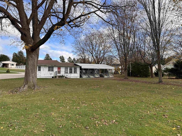 single story home featuring a front lawn and a carport