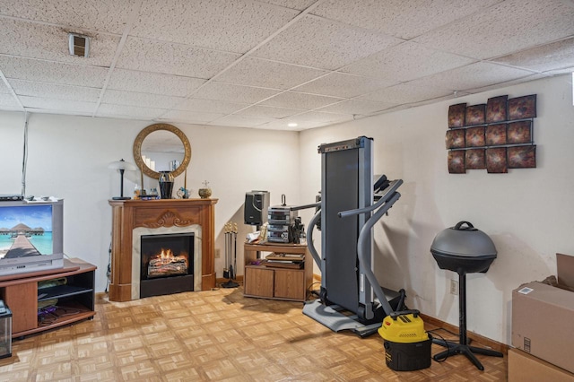 workout area with parquet floors and a drop ceiling