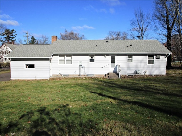 rear view of house featuring a lawn