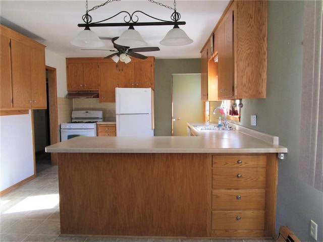 kitchen with hanging light fixtures, white appliances, ceiling fan, and sink