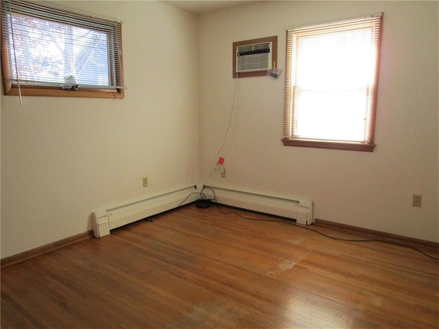 spare room with a wall mounted AC and hardwood / wood-style flooring