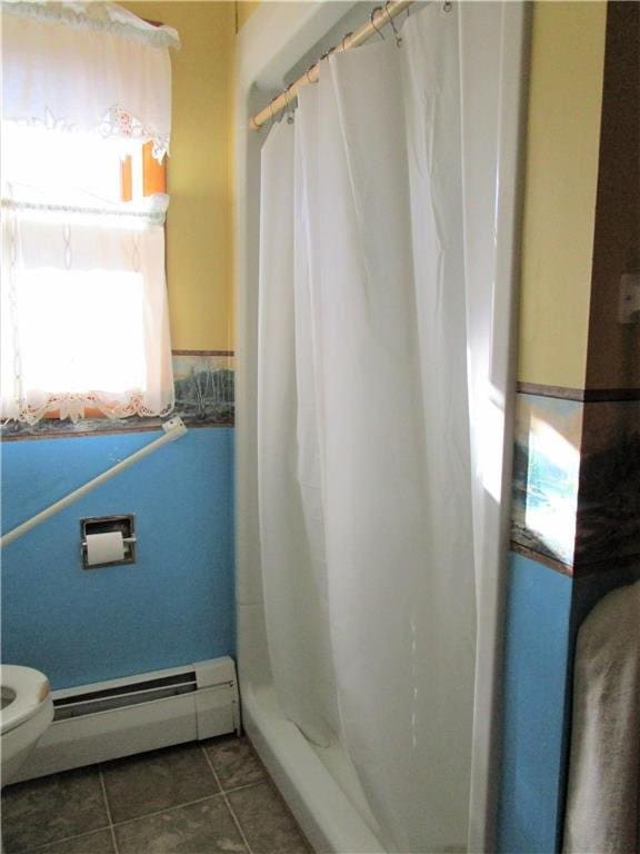 bathroom with baseboard heating, walk in shower, tile patterned floors, and toilet