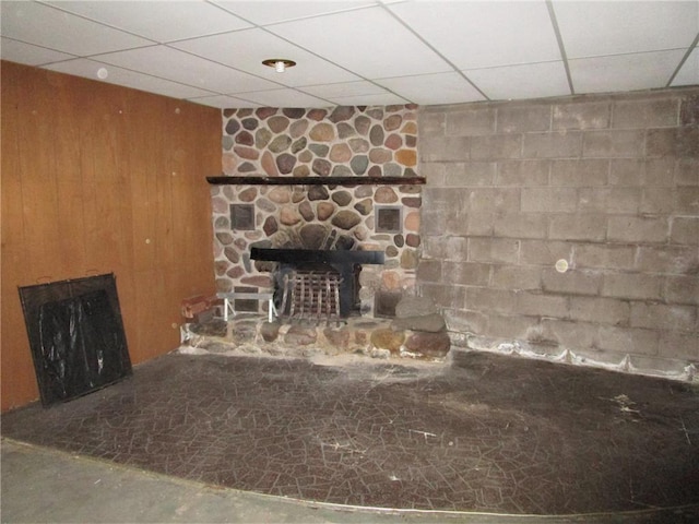 details featuring wood walls, a paneled ceiling, concrete flooring, and a fireplace