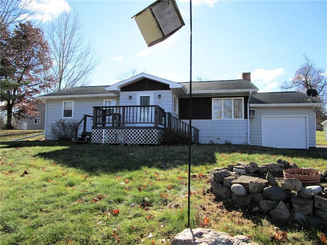 back of property featuring a garage, a lawn, and a wooden deck