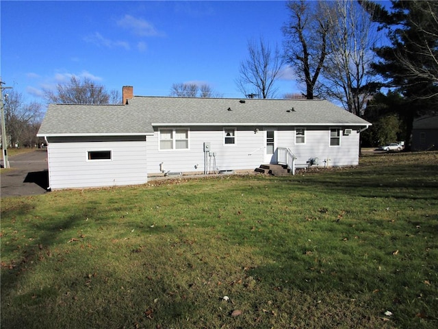 rear view of property featuring a lawn