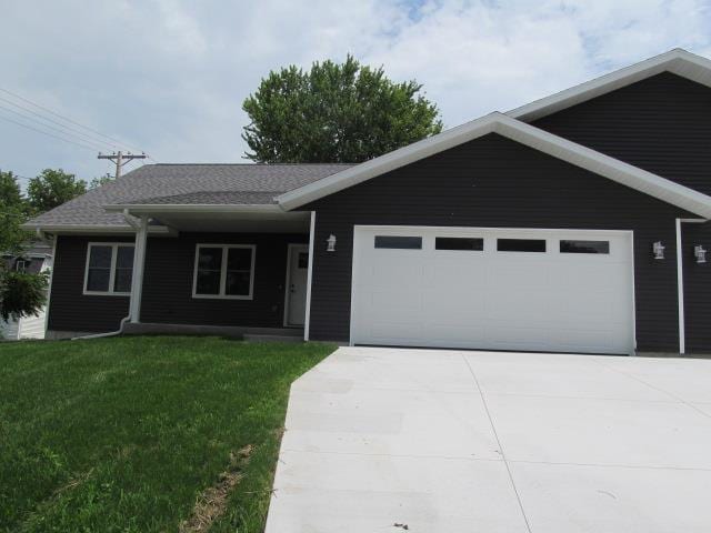 ranch-style house with a garage and a front lawn