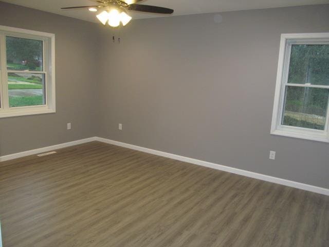 empty room featuring dark wood-type flooring and ceiling fan