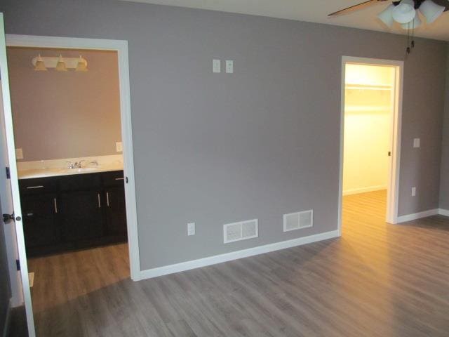 unfurnished room featuring light hardwood / wood-style flooring, ceiling fan, and sink