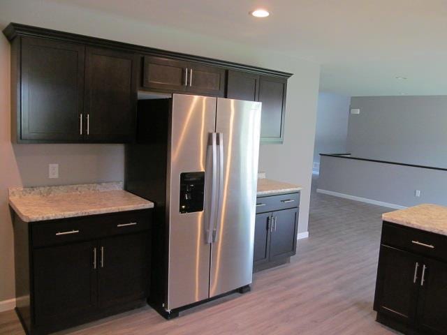 kitchen featuring stainless steel fridge and light hardwood / wood-style flooring