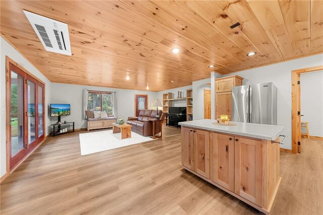 kitchen featuring light brown cabinets, light wood-type flooring, a kitchen island, wood ceiling, and stainless steel refrigerator