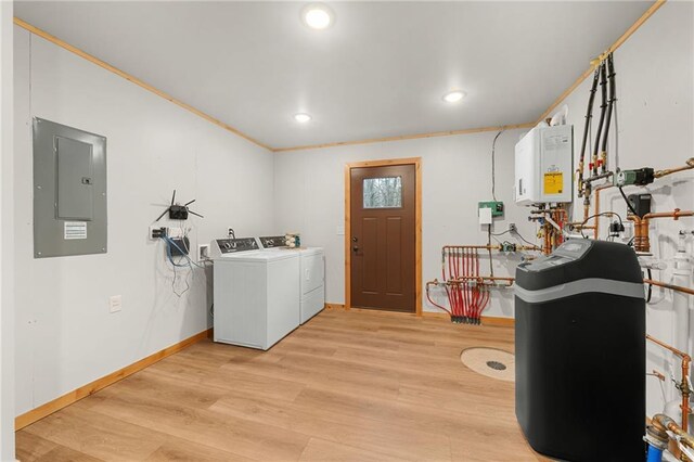 clothes washing area featuring tankless water heater, washing machine and dryer, electric panel, crown molding, and light hardwood / wood-style floors