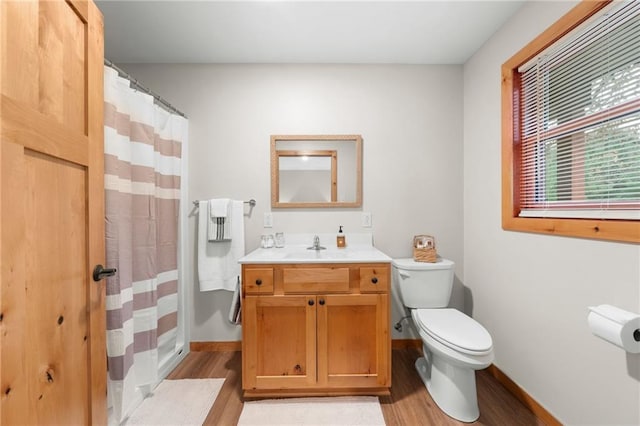 bathroom featuring vanity, toilet, wood-type flooring, and walk in shower