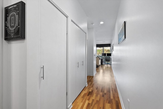 corridor with hardwood / wood-style flooring