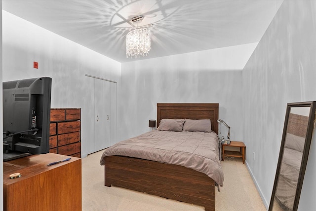 bedroom with light carpet and a notable chandelier