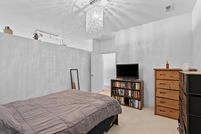 carpeted bedroom featuring an inviting chandelier and rail lighting