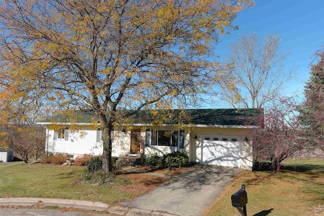 ranch-style house featuring a garage and a front lawn