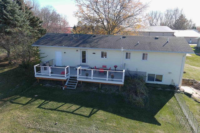 rear view of house with a wooden deck and a yard