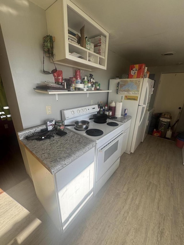 kitchen with white appliances and light hardwood / wood-style floors