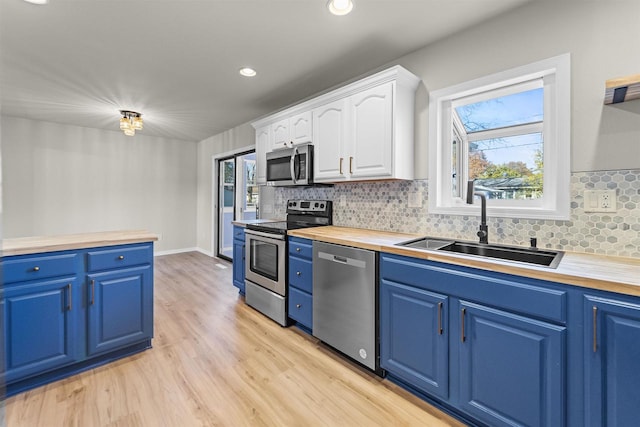 kitchen with white cabinetry, sink, appliances with stainless steel finishes, and blue cabinetry