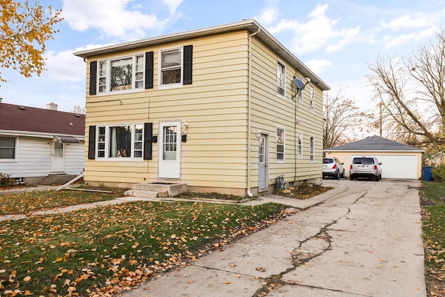 view of front of home with a front lawn, a garage, and an outdoor structure