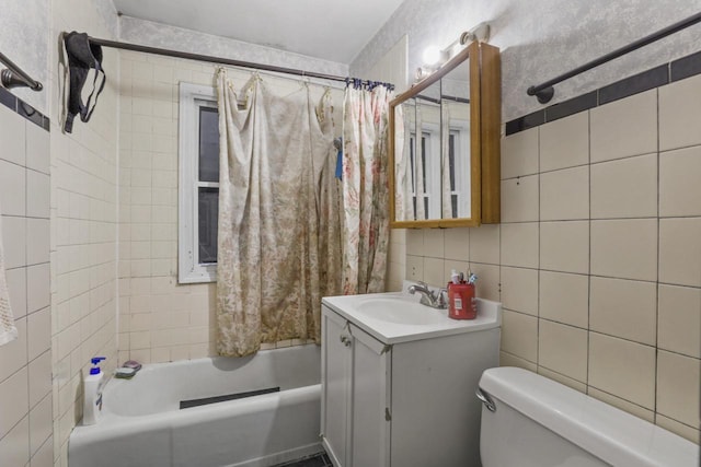 full bathroom with tasteful backsplash, tile walls, vanity, toilet, and shower / bath combo with shower curtain