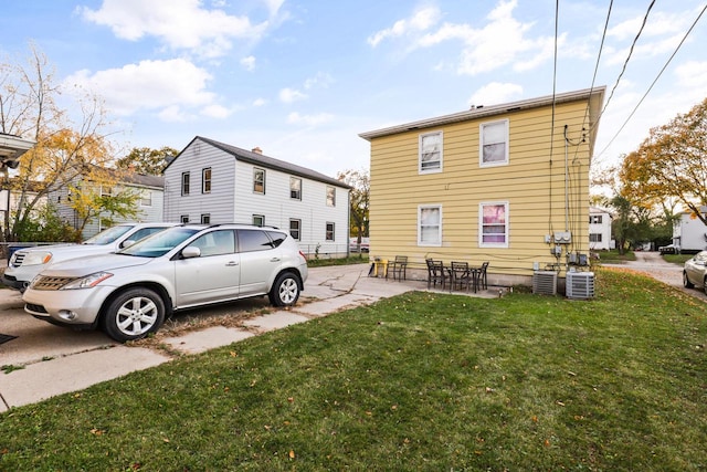 exterior space with central air condition unit, a yard, and a patio area