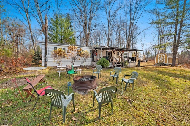 view of yard featuring a shed, a fire pit, and a porch