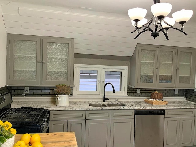 kitchen featuring dishwasher, sink, black gas range oven, and backsplash