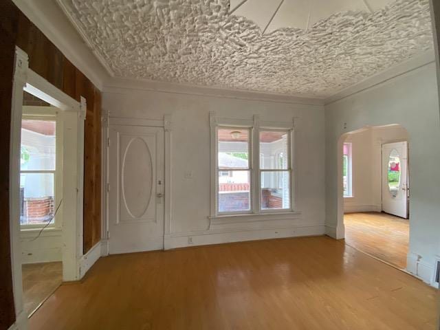 foyer entrance with light hardwood / wood-style floors and crown molding