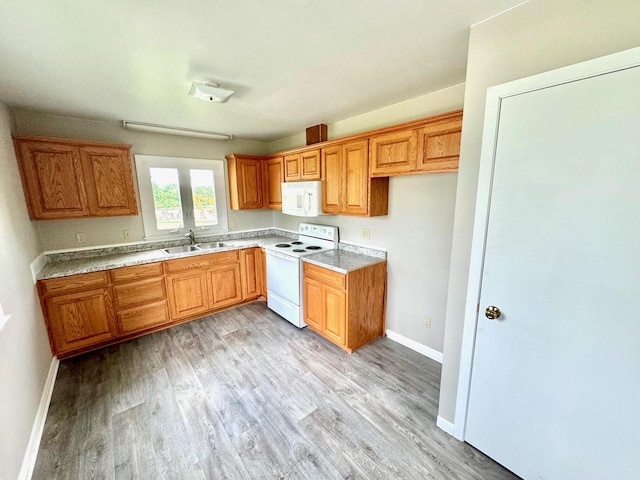 kitchen featuring white appliances, sink, and light wood-type flooring